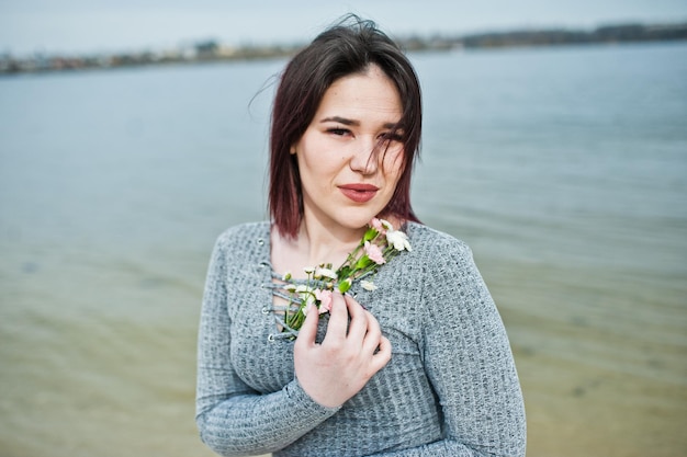 Ritratto di ragazza bruna in abito grigio sullo sfondo del lago