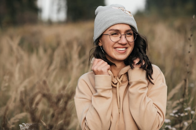 ritratto di ragazza bruna sorridente con gli occhiali nel campo