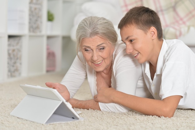 Ritratto di ragazza con la nonna utilizzando tablet
