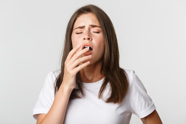 Ritratto di ragazza con starnuti allergici, coprire la bocca con la mano.