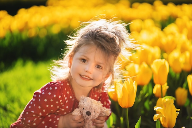 Ritratto di ragazza con un orsacchiotto in mano sullo sfondo dei fiori Pace in Ucraina