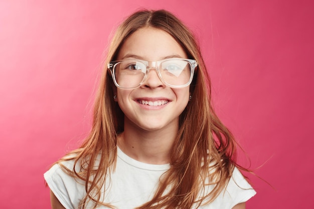 Ritratto di ragazza dai capelli castani su sfondo rosa