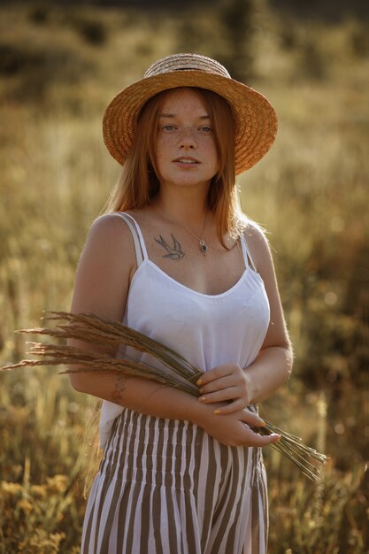 Ritratto di ragazza dai capelli rossi in un cappello. ragazza su uno sfondo verde