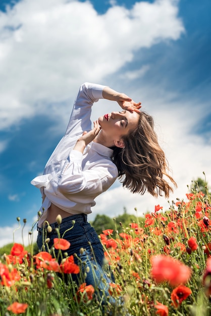 Ritratto di ragazza di bellezza e moda nel campo del papavero. estate