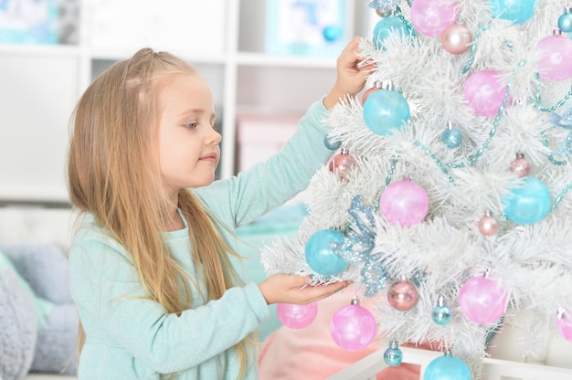 Ritratto di ragazza felice che decora l'albero di Natale