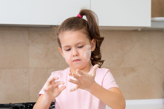 Ritratto Di Ragazza Felice Con La Faccia Disordinata In Piedi In Cucina