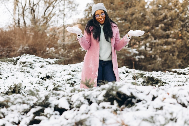 Ritratto di ragazza felice La giovane donna afroamericana in occhiali e guanti sorride in inverno