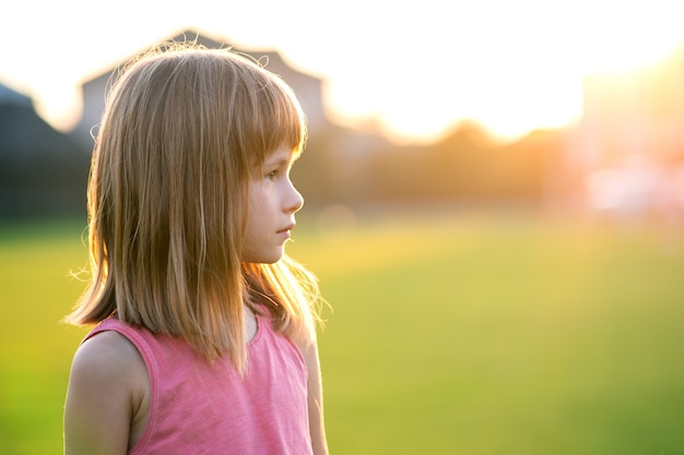 Ritratto di ragazza giovane bambino felice rilassante all'aperto nelle calde sere d'estate.