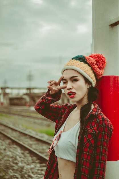 Ritratto di ragazza hipster sedersi sulla ferrovia vintage stylethai donna in posa per scattare una foto