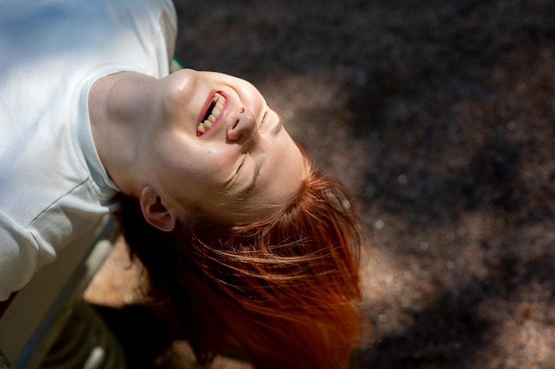 Ritratto di ragazza ridente allegra con i capelli lunghi sullo sfondo della natura