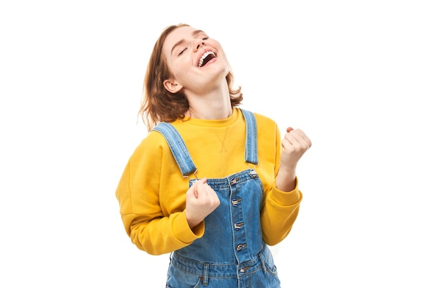 Ritratto di ragazza rossa positiva in jeans casual si rallegra emotivamente e si sente felice isolato su sfondo bianco banner pubblicitario