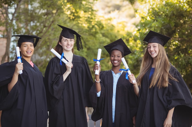 Ritratto di ragazzi delle scuole di specializzazione in piedi con scorrimento di laurea nel campus