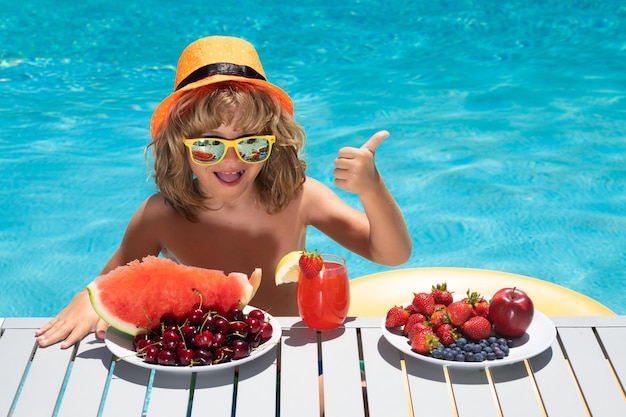 Ritratto di ragazzini estivi con frullato di frutta e succo di frutta nella piscina estiva bambino in estate v