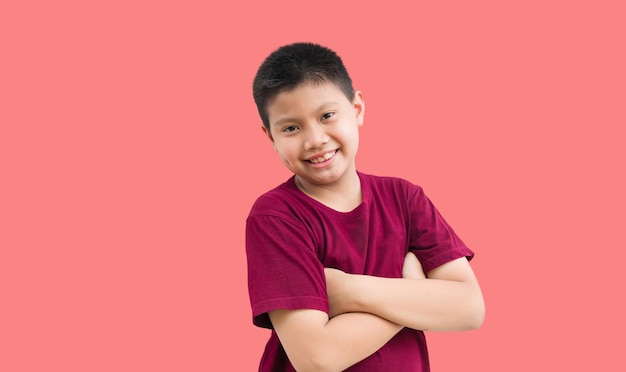 Ritratto di ragazzino asiatico in piedi sorridente con le braccia incrociate gesto sicuro