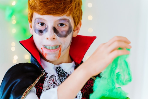 Ritratto di ragazzino dai capelli rossi vestito come un vampiro spettrale per Halloween