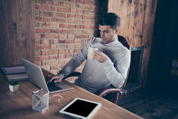 Ritratto di ragazzo che beve bevanda industriale loft area di lavoro interna