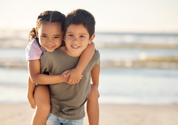 Ritratto di ragazzo e ragazza in spiaggia durante le vacanze estive in famiglia durante il tramonto Bambini felici o fratelli abbraccio giocano e sorridono all'oceano o al mare con libertà cura e sorriso durante le vacanze nella natura