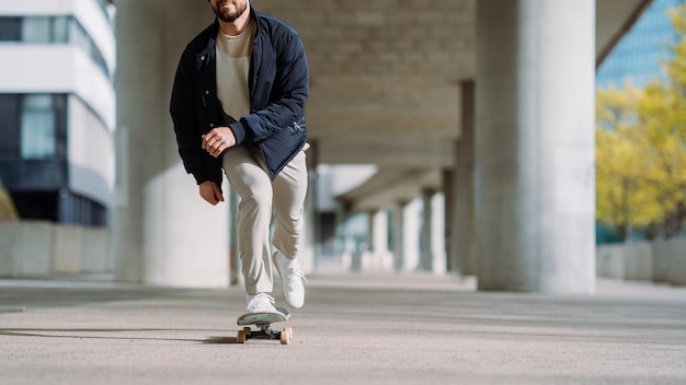 Ritratto di ragazzo skater attivo in equilibrio su skateboard su sfondo urbano Skateboarder focalizzato