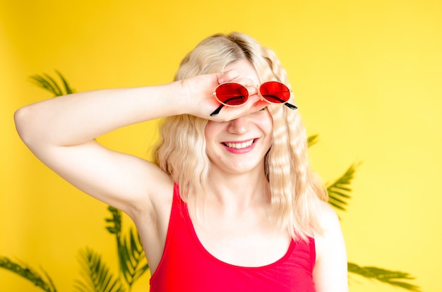 Ritratto di ridere ragazza bionda con gli occhiali da sole