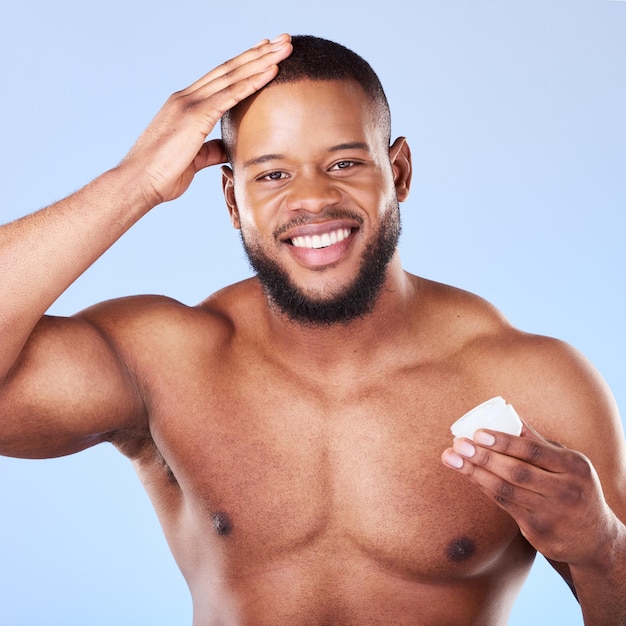 Ritratto di salute e un uomo nero con crema per la cura dei capelli lucentezza e umidità su uno sfondo di studio felice benessere e una persona africana o modello con gel per la crescita isolato su uno sfonto