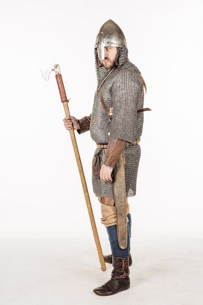 Ritratto di soldato slavo medievale in piedi e pronto per una lotta con l'immagine di usbergi del casco dell'ascia su concetto storico di sfondo bianco per studio