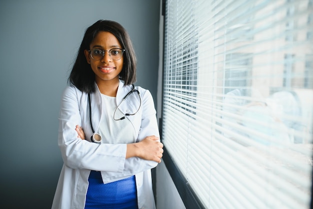 Ritratto di sorridente dottoressa indossa camice bianco con stetoscopio in ospedale