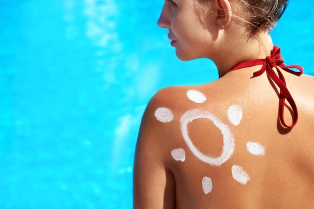 Ritratto di splendida donna in bikini con il sole disegnato su una spallaCrema solare