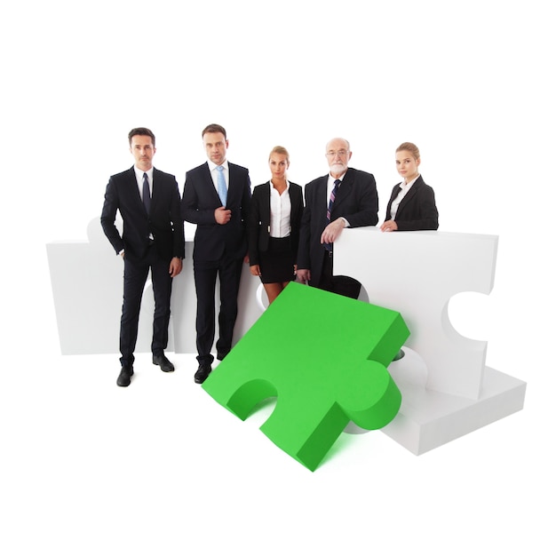 Ritratto di squadra di affari e puzzle isolato su sfondo bianco