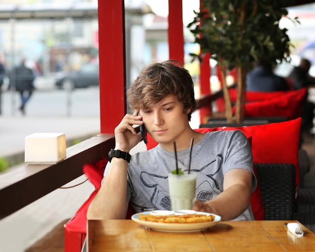 Ritratto di stile di vita di un giovane che usa uno smartphone all'aperto