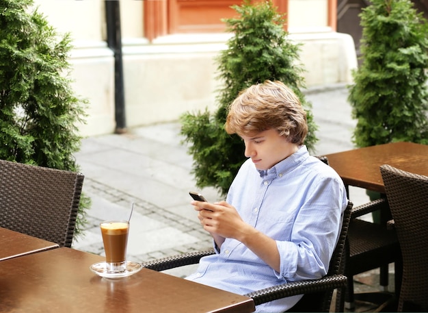 Ritratto di stile di vita di un giovane che utilizza uno smartphone all'aperto