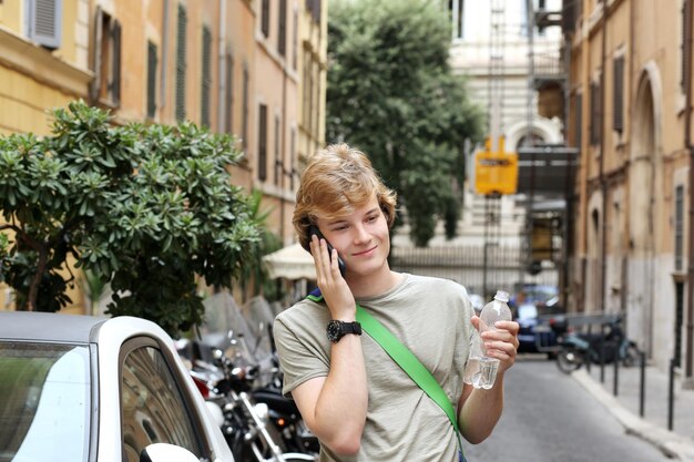 Ritratto di stile di vita di un giovane uomo che si rilassa, un turista che guarda una mappa e usa uno smartphone.