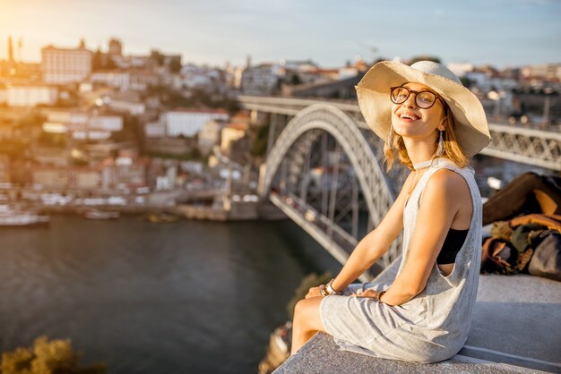 Ritratto di stile di vita di una giovane turista che gode di una splendida vista sulla città vecchia e sul fiume nella città di Porto durante il tramonto in Portogallo