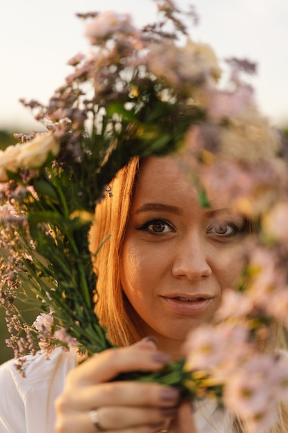 Ritratto di stile di vita estivo di bella giovane donna in una ghirlanda di fiori selvatici ghirlanda sulla sua testa