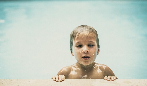 Ritratto di stile di vita ragazzo serio nuotare in piscina dopo un duro allenamento stanco emergere su espressione facciale triste infanzia acqua mentale psicologia della scuola sensazione di carico di lavoro diritti dei bambini stanchezza esaurimento