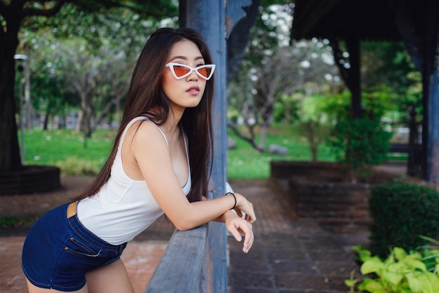 Ritratto di stile di vita soleggiato estivo di giovane donna alla moda hipster che cammina per strada indossando un vestito carino alla moda Giovani donne asiatiche viaggiatore turistico sorridente nella moda di strada di Bangkok