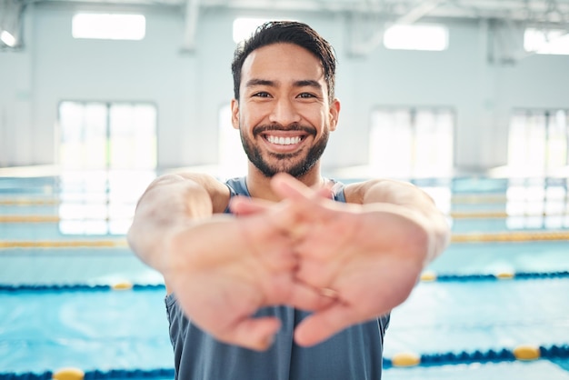 Ritratto di stretching e uomo in piscina per l'allenamento cardio ed esercizio al coperto e flessibile Sorriso del viso e allungamento del nuotatore prima dell'allenamento routine di nuoto e fitness riscaldamento e preparazione