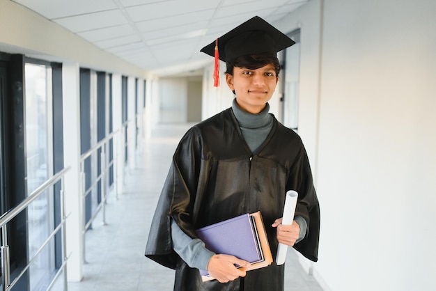 Ritratto di studente indiano di successo in abito di laurea