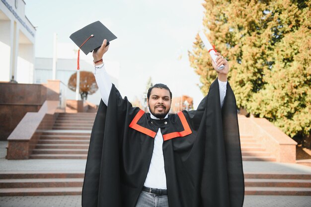 Ritratto di studente indiano di successo in abito di laurea