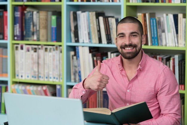 Ritratto di studente intelligente e mostrando i pollici in su