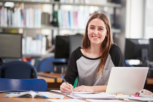 Ritratto Di Studentessa Che Lavora Al Computer Portatile Nella Biblioteca Del College