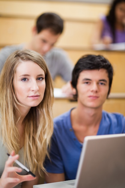 Ritratto di studenti in posa con un computer portatile