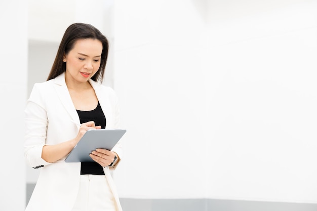 Ritratto di successo Una donna d'affari asiatica di mezza età che tiene tablet sorridente alla telecamera