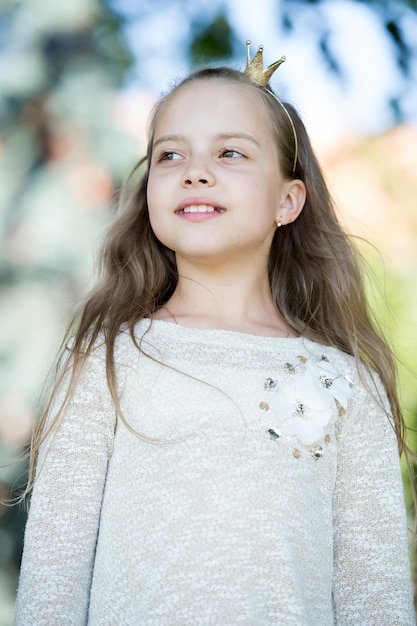Ritratto di un'adorabile piccola principessa carina e felice con lunghi capelli biondi ricci in una giornata di sole estivo