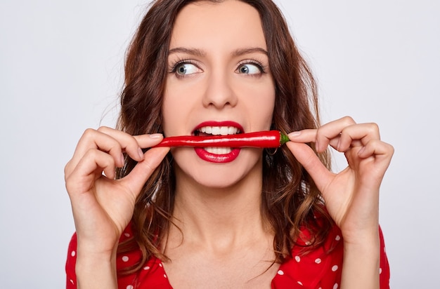 Ritratto di un'affascinante giovane donna graziosa con peperoncino.