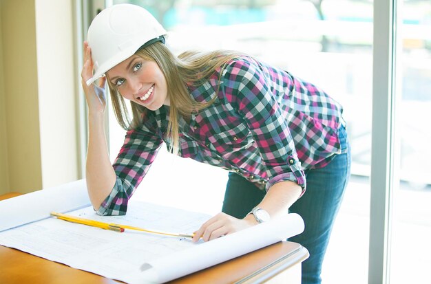 Ritratto di un architetto sorridente con una stampa blu sul tavolo