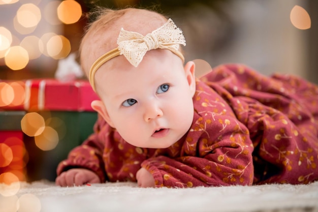 Ritratto di un bambino a casa sullo sfondo di un albero di Natale e ghirlande Articolo sui bambini Primo capodanno del bambino