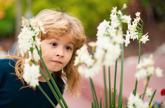 Ritratto di un bambino bellissimo nel giardino in fiore d'estate Un bambino felice sul prato con fiori bianchi