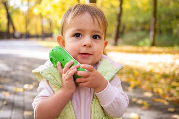 Ritratto di un bambino carino che gioca a parlare con un telefono giocattolo