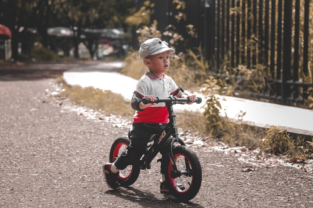 ritratto di un bambino carino che guida una bicicletta a spinta