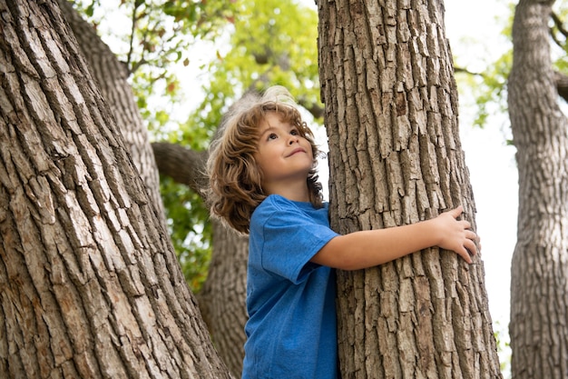 Ritratto di un bambino carino che si arrampica su un albero in un parco